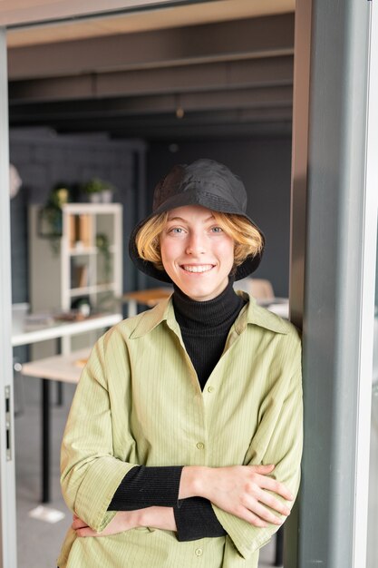 배경에 사무실 문을 열고 서있는 동안 이빨 미소로 당신을 찾고 casualwear에서 젊은 밝은 금발 사업가