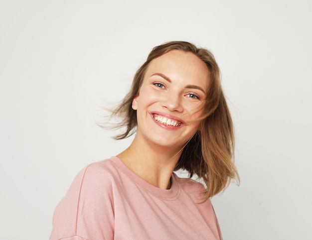 Young and cheerful blonde woman smiling and laughing looking at the camera