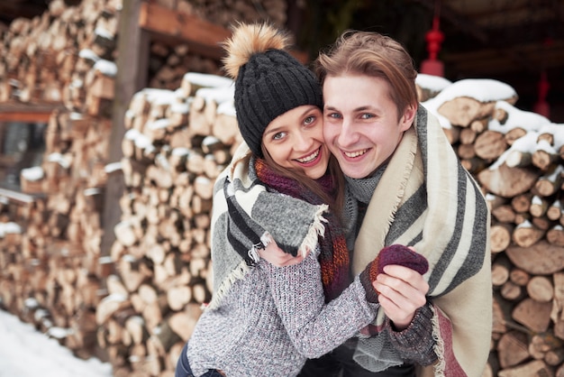 Young cheerful couple in a cabin in romantic scape in winter