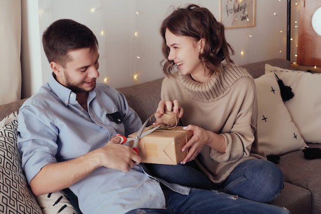 Photo young cheerful couple in love with gift for christmas.