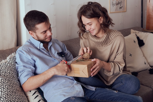 Young cheerful couple in love with gift for Christmas.