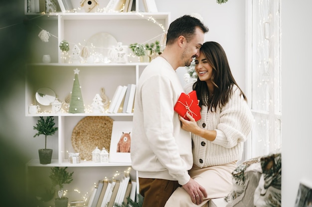 Young cheerful couple in love with present for christmas