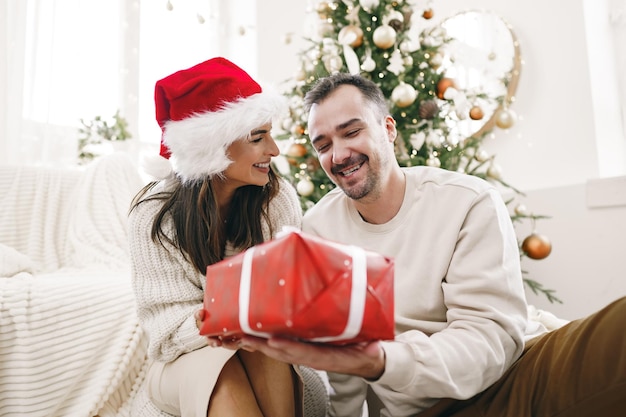 Young cheerful couple in love with present for christmas