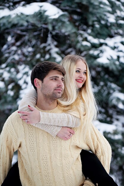 Young cheerful couple in the park in winter