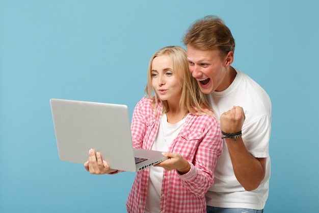 Young cheerful couple two friends man and woman  in white pink empty t-shirts posing 