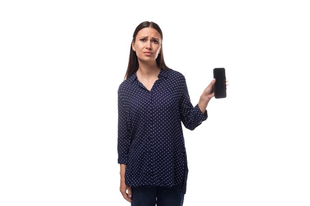 Young cheerful cute caucasian brunette lady dressed in dark blue blouse holding smartphone with