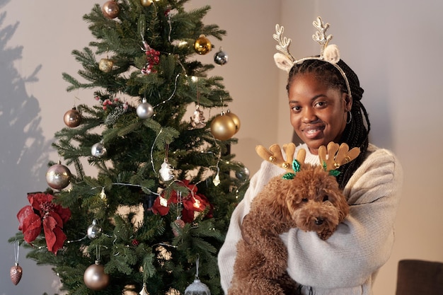 Photo young cheerful female holding purebred domestic dog