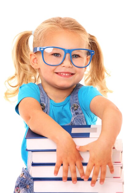 Photo young cheerful girl resting her arms on the pile of books against white background