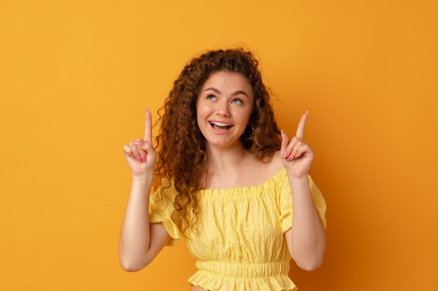 Young cheerful girl smiling point finger to copy space