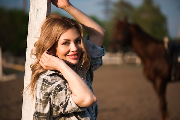 Young cheerful girl with her favorite horse.