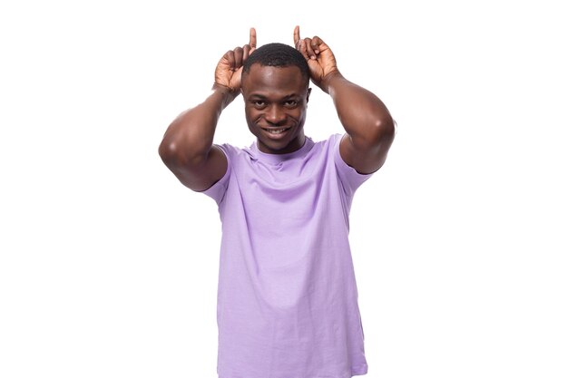 Young cheerful handsome african man in lilac tshirt laughing on white background