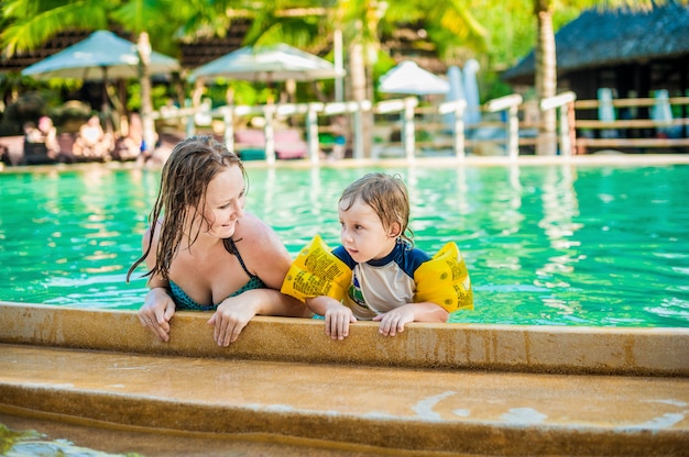 Young cheerful mother and son in a swimming pool