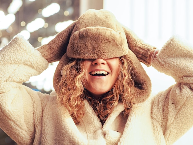 Photo young cheerful woman wearing knit hat on face