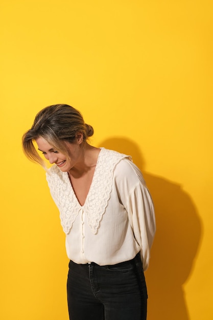 Young cheerful woman on yellow background