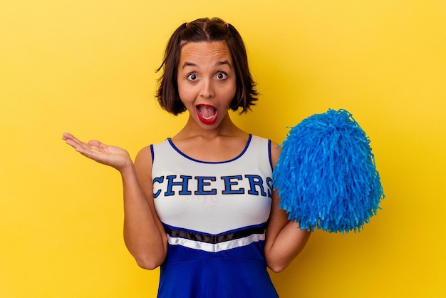 Young cheerleader mixed race woman isolated on yellow background surprised and shocked.