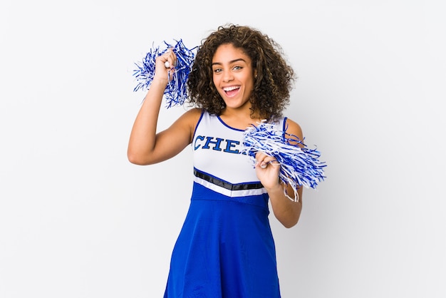 Young cheerleader woman isolated on white wall