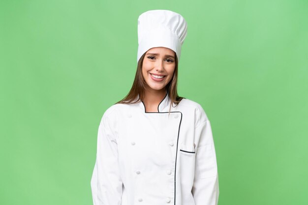 Young chef caucasian woman over isolated background laughing