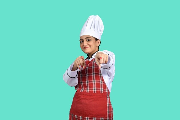 young chef girl front pose pointing on camera indian pakistani model