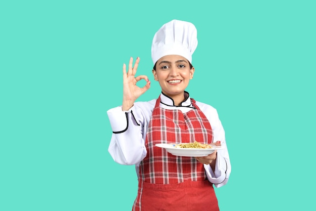 young chef girl white outfit holding a plate ok sign indian pakistani model