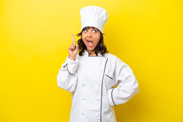 Young chef latin woman isolated on yellow background