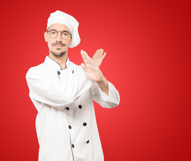 Photo young chef making a gesture of not crossing with the arms