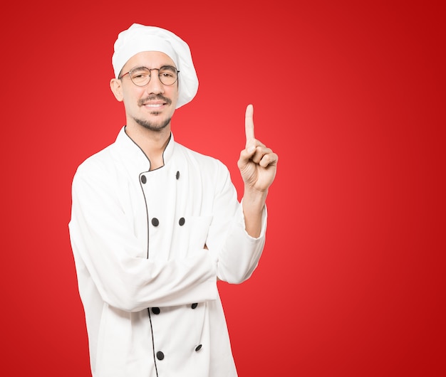 Young chef making a number one gesture