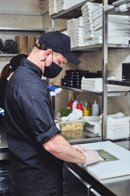 Foto giovane chef che prepara sushi in un ristorante