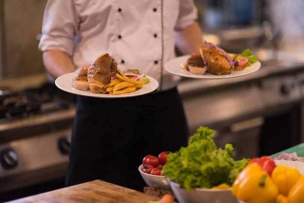 young Chef presenting dishes of tasty meals in commercial kitchen