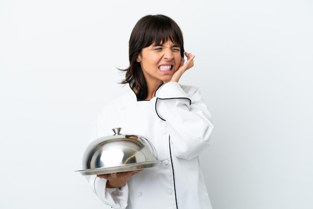 Young chef with tray isolated on white background frustrated and covering ears