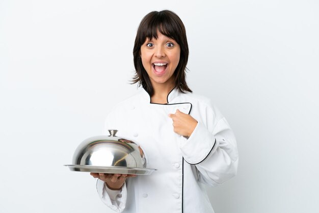 Young chef with tray isolated on white background with surprise facial expression