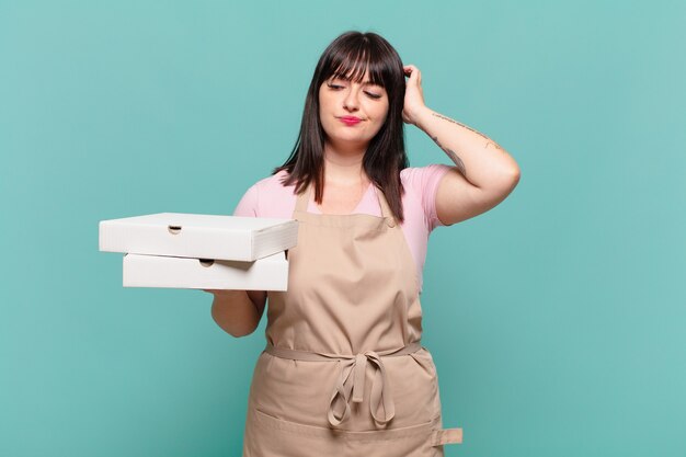 Young chef woman feeling puzzled and confused, scratching head and looking to the side