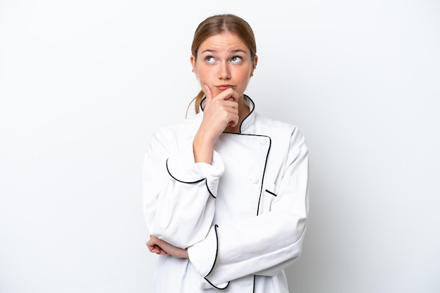 Young chef woman isolated on white background having doubts and with confuse face expression