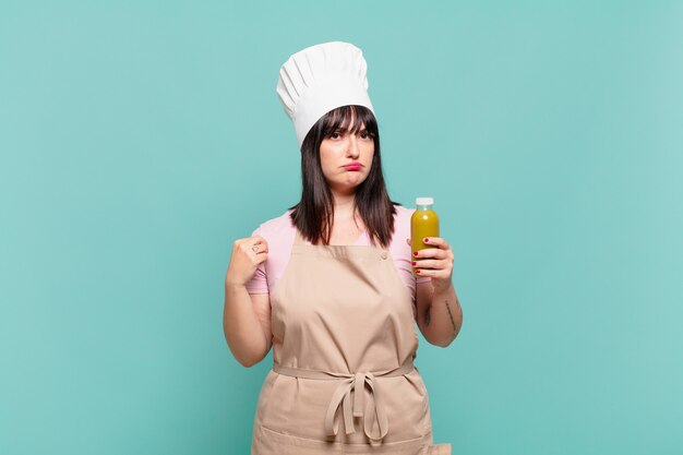 Young chef woman looking arrogant, successful, positive and proud, pointing to self