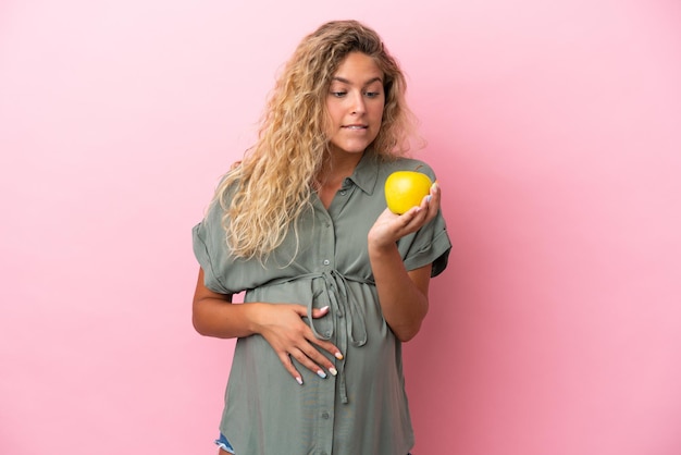 Young chef woman using hand blender isolated on pink background happy and smiling covering mouth with hand