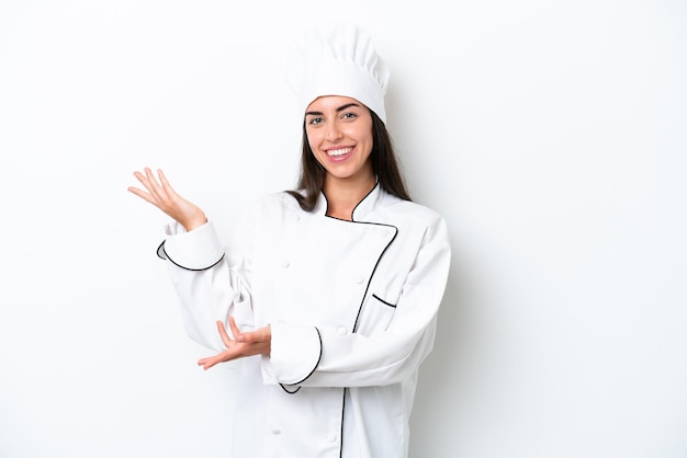 Young chef woman over white background extending hands to the side for inviting to come