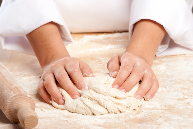 young chef working the dough with hands