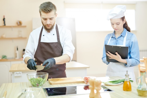 Giovane chef che lavora nel ristorante con assistente