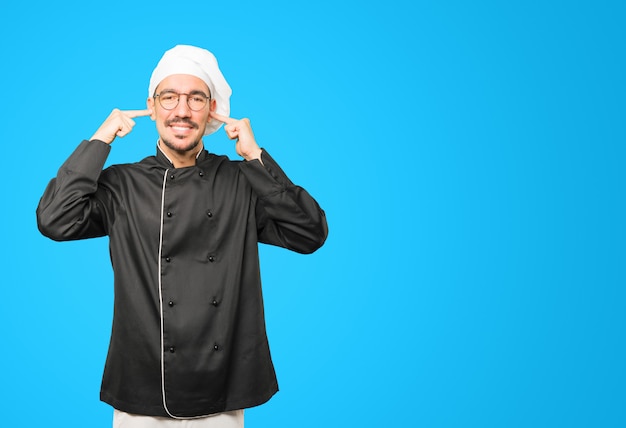 Young chef worried about loud noises and covering his ears