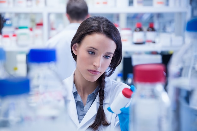 Young chemist picking up the bottles on the shelf