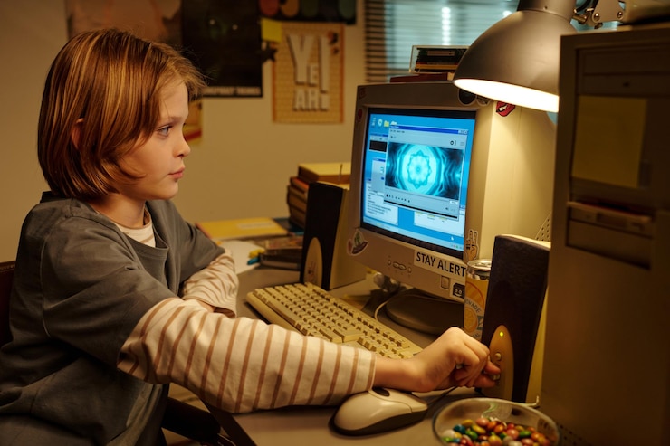 Photo young child exploring computer at desk indoors