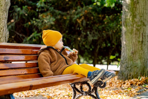 Young Child Sitting on Park Bench A young child enjoys a moment of solitude while sitting on a park bench