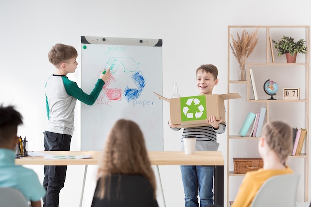 Young children drawing recycle sign