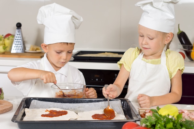 Photo young children making themselves a homemade pizza