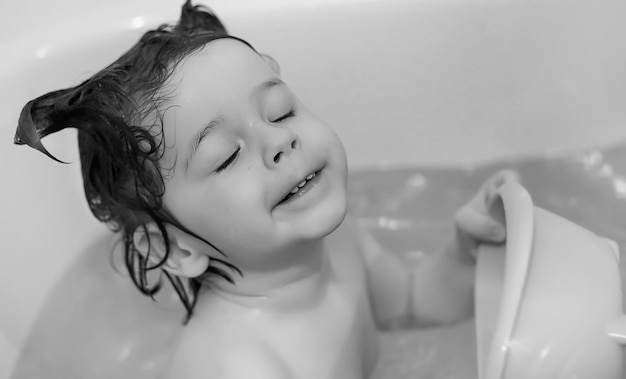 Photo young children take a bath. children wash in bathroom. brother and sister play in the bathroom during water procedures.