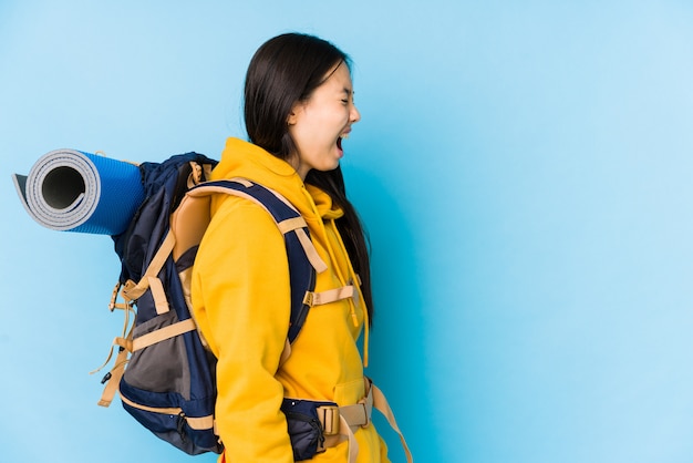 La giovane donna cinese di viaggiatore con zaino e sacco a pelo ha isolato gridare verso uno spazio della copia