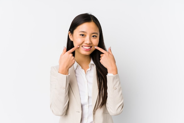 Young chinese business woman isolated smiles, pointing fingers at mouth.