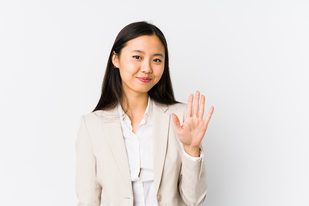 Молодая китайская бизнес-леди изолировала усмехаясь жизнерадостный показ 5 с пальцами.