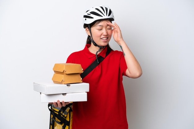 Young Chinese delivery woman taking takeaway food isolated on white background smiling a lot