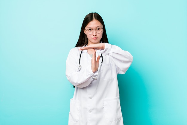 Young chinese doctor woman showing a timeout gesture.