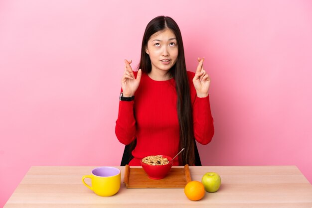 Young Chinese girl having breakfast in a table